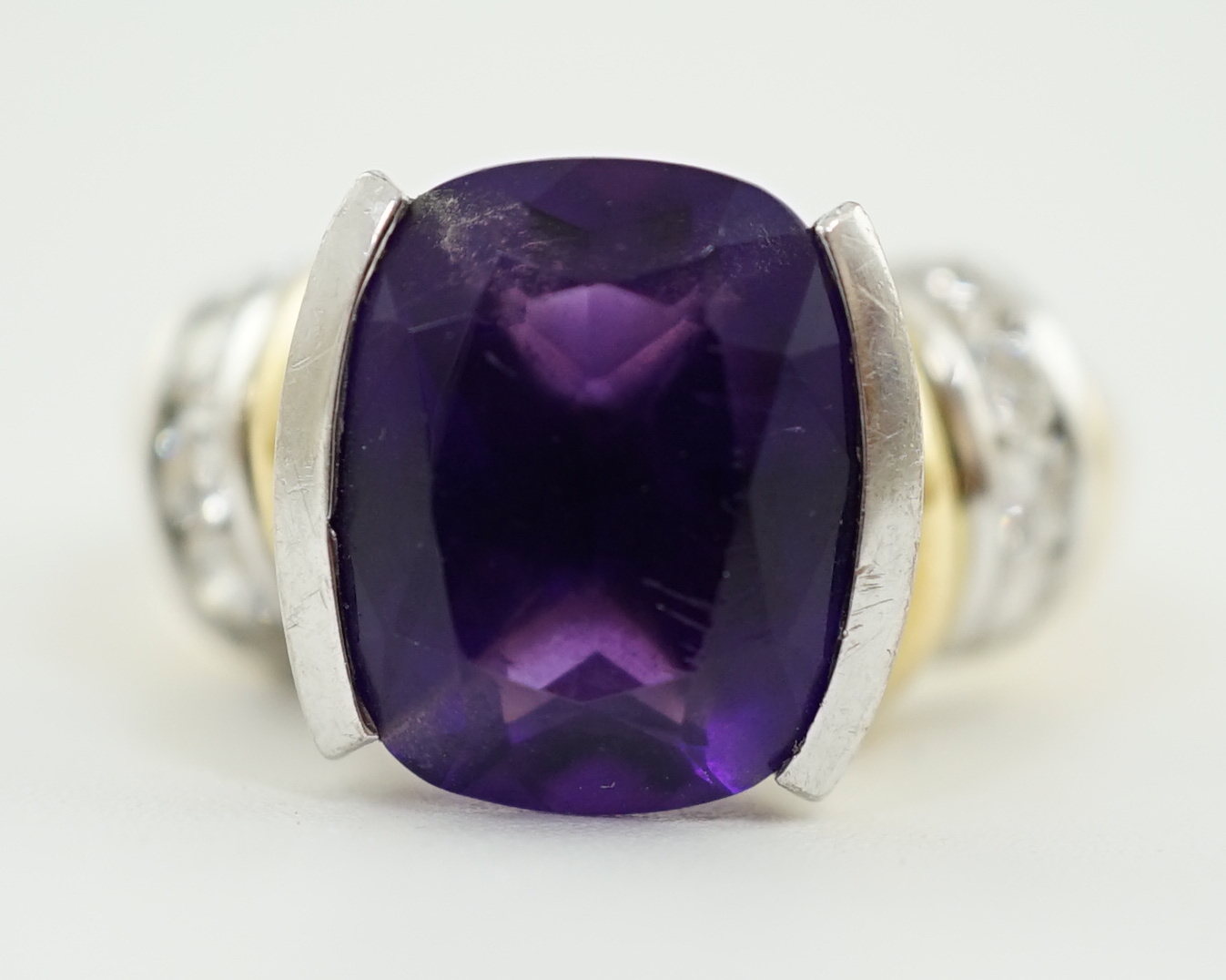A modern 18ct gold and single stone cushion cut amethyst set dress ring, with ten stone round brilliant cut diamond set shoulders